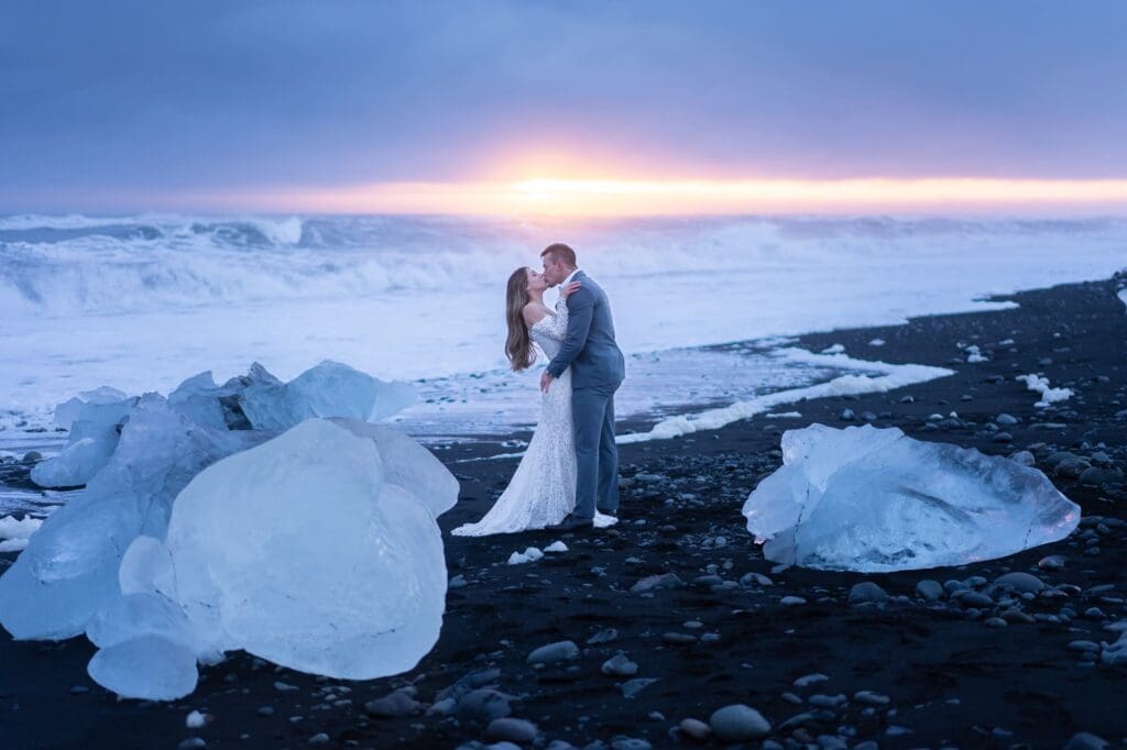 Sunset elopement at Diamond Beach in Iceland among large ice chunks on the black sand