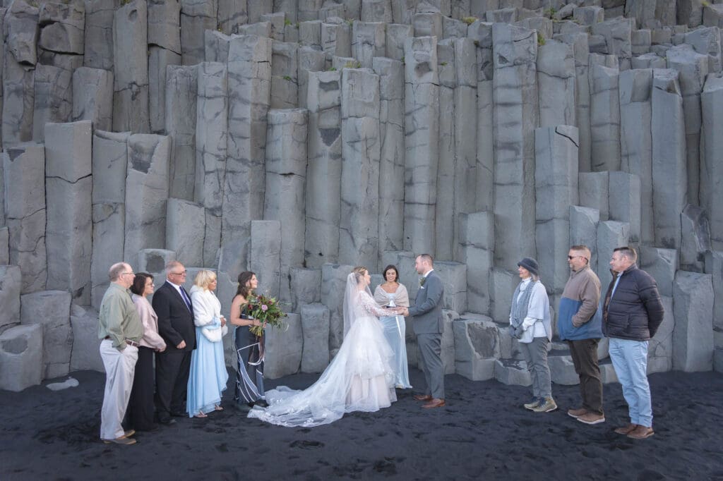 Intimate wedding ceremony in front of basalt columns at Reynisfjara in Iceland