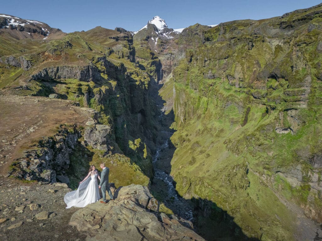 View from above on Mulagljufur canyon in iceland with a couple in their wedding attire