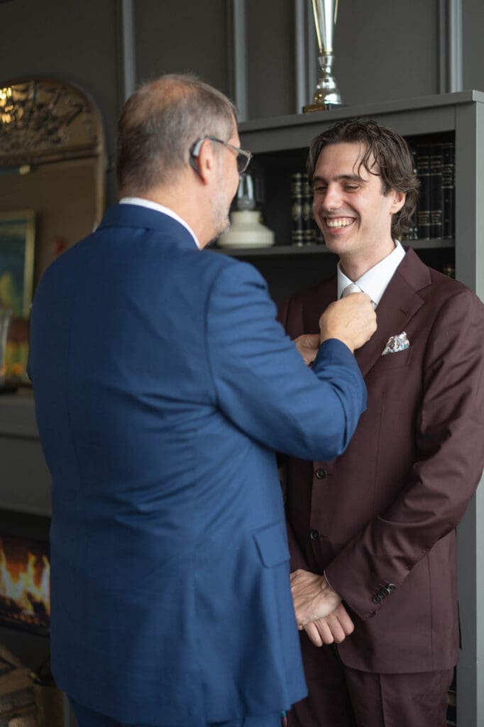 Father of groom is fixing his son's tie