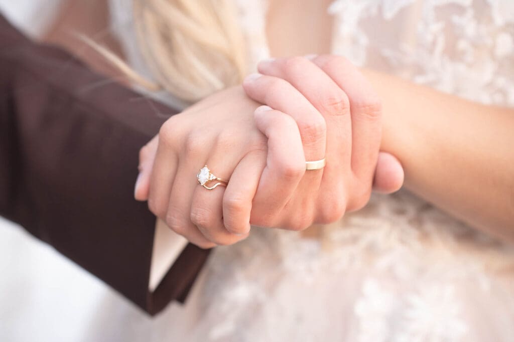 A closeup of the hands of a married couple with their rings on