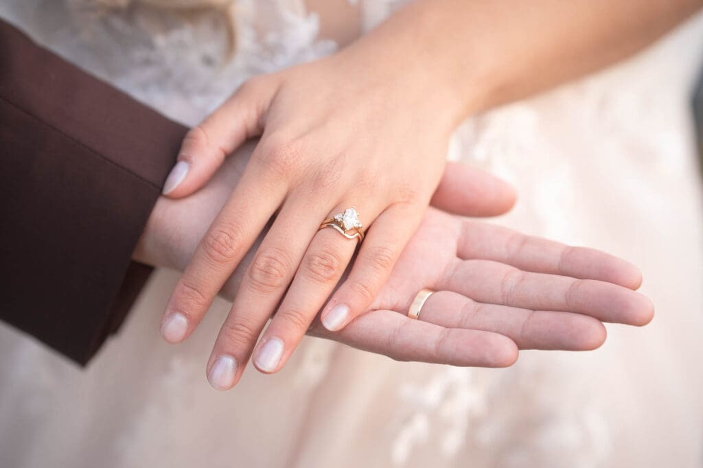 A closeup of the hands of a married couple with their rings on