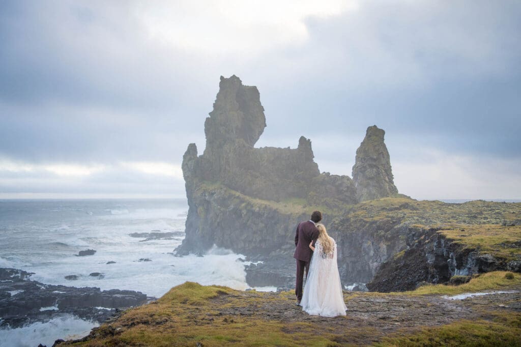Bride and groom in Snaefellsnes Peninsula enjoying the view by the ocean