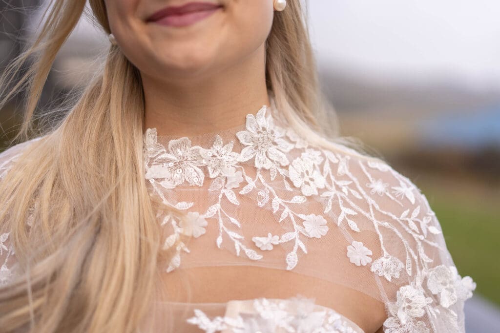 Details of the front of a lace wedding dress cape